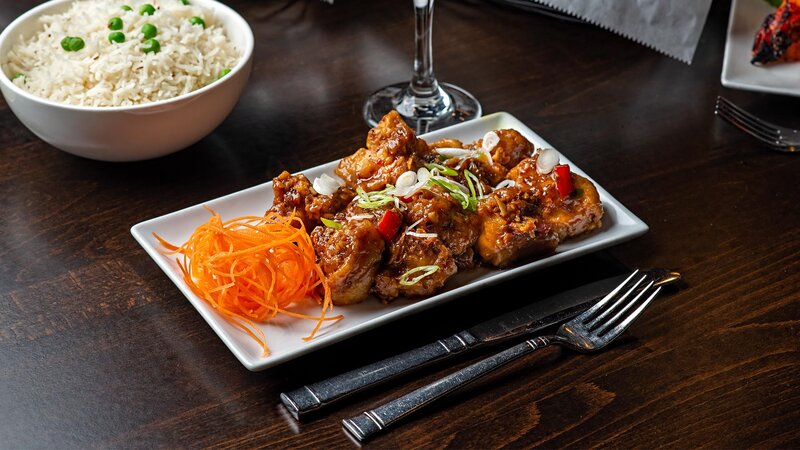 Marinated chicken topped with peppers with a side of shredded carrots